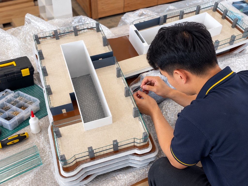 Kỹ thuật viên kiểm tra bảo trì và hoàn thiện chi tiết sa bàn tại xưởng